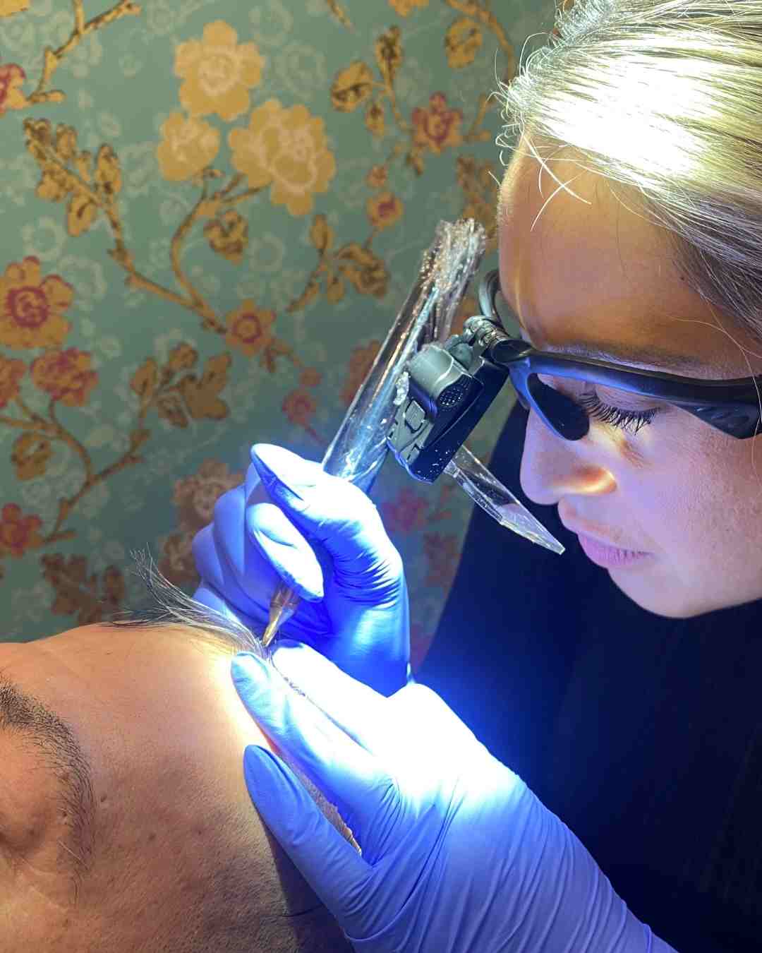 Student learning scalp micropigmentation techniques at Institute of Ink